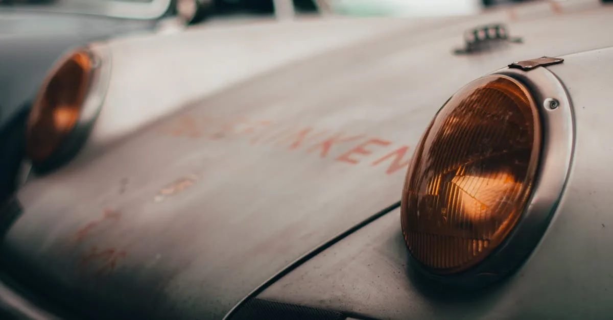 Close-up of a decaying, moss-covered vintage car in the woods.
